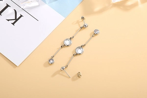 Detail view of long tassel earrings in silver finish with sparkling rhinestone accents