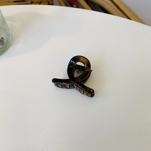 Detail of amber tortoiseshell claw clip showing durable resin material and black spring
