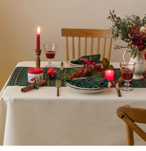 Close-up of green and yellow plaid table runner with festive Christmas dining decorations