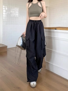 Detail of high-waist black cargo pants with large side pockets and drawstring waist