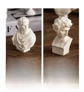 Close-up of mini David resin statues with detailed carvings on a wooden desk