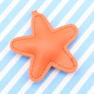 Orange starfish-shaped PU leather keychain with visible stitching on a striped background