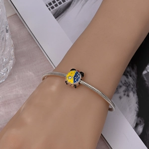 Detail of silver snake chain bracelet with Disney Mickey-style sun and moon charm