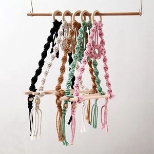 Detail of bohemian hand-woven macrame towel holders in various colors with wooden bars