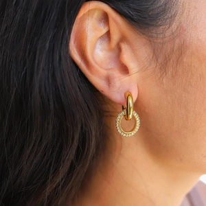 Close-up of gold stainless steel hoop earring with a sparkling pavé zircon pendant
