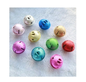 Close-up of multicolored glitter star bells on white faux fur for DIY crafts decoration