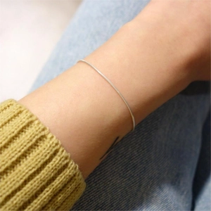 Minimalist S925 sterling silver snake bone bracelet with shiny metallic finish on wrist