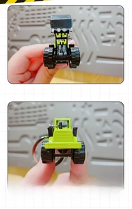 Detail view of mini alloy bulldozer keychain showing solid build and green finish
