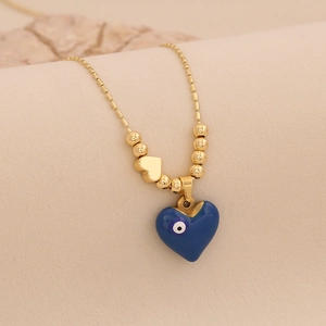 Détail de la chaîne dorée à perles et pendentif cœur en émail bleu œil grec