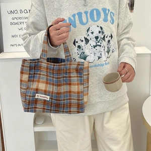 Detail of the vintage plaid tote bag featuring blue and orange textured woven fabric