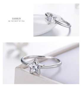 Macro shot of silver S925 star ring with cubic zirconia on white ceramic and jewelry box