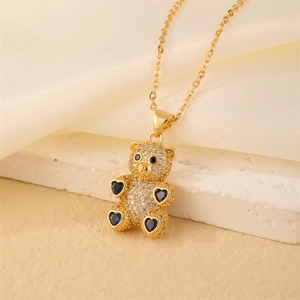 Detail of a gold bear pendant with micro-paved diamonds and blue heart-shaped gems