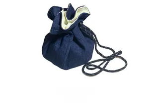 Detail of drawstring denim storage bag and crossbody strap with functional design