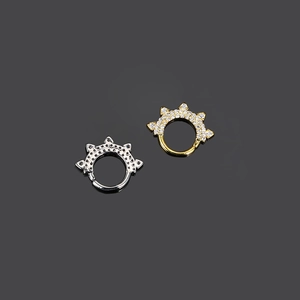 Dettaglio di anelli per il naso a forma di corona in oro e argento con zirconi lucidi