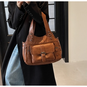 Brown PU leather tote bag with multiple pockets and metal hardware shown on model