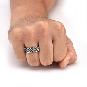 Detailed view of silver stainless steel dragon scale spinning ring on male finger