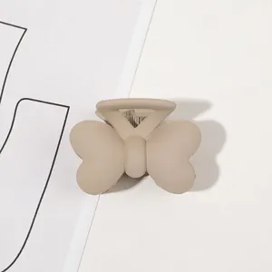 Detailed view of matte milk tea butterfly hair claw clip with sturdy styling teeth