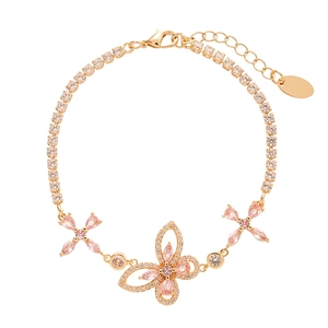 Elegant gold butterfly bracelet with pink zircons and floral charms on white background