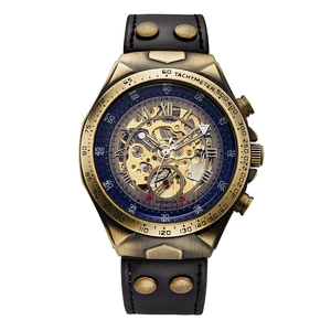 Detail view of skeleton mechanical watch with bronze case, gold gears, and black leather strap