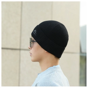 Close-up of a black street style knitted beanie featuring a mountain embroidery detail