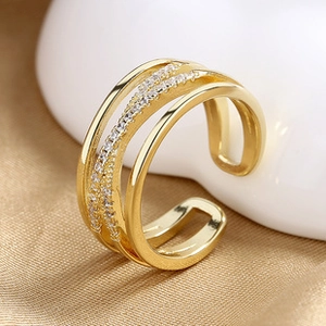 Detail of layered gold open ring with shimmering zircon stones on silk background