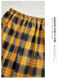 Detail view of yellow and black plaid pajama pants with an elastic waistband design