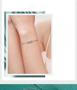 Close-up of S925 sterling silver infinity bracelet with turquoise and small blue stones