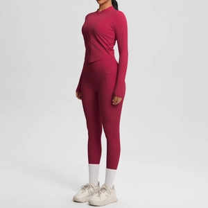 Détail d'un ensemble de yoga bordeaux avec legging sans couture et veste zippée ajustée