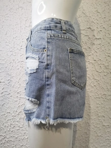 Détail du short en jean bleu clair vieilli avec ourlets effilochés et poches latérales