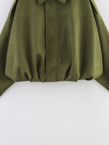 Detail of the elastic hem and suede fabric texture on a green bomber jacket