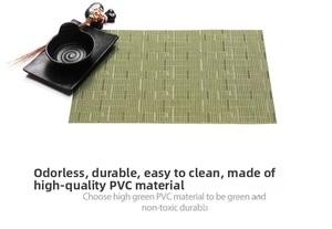 Detail of green PVC woven placemat showing non-slip texture with black tableware decor