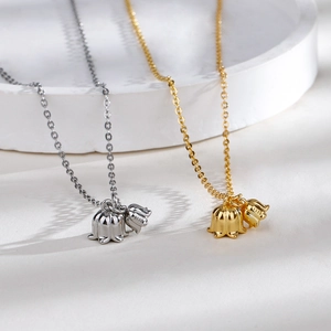 Elegant gold and silver Lily of the Valley S925 sterling silver necklaces set on white tray