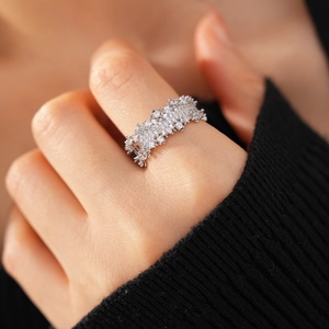 Close-up of luxurious silver open ring with pavé zircon stones on a model hand