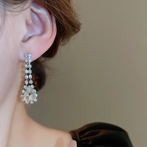 Detailed view of silver-toned metal fringe earrings with sparkling drop-shaped crystals