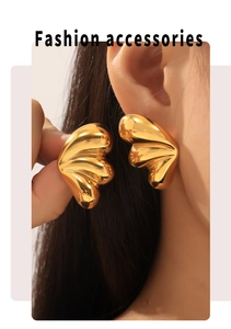 Close-up of chunky gold-plated fan-shaped stud earrings showing high metallic luster