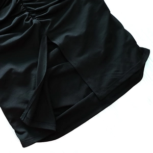 Detail of black slim-fit dress featuring side ruching and a slit hem design