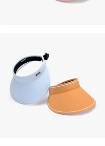 Close-up of blue and orange sun visors with wide brims and adjustable back buckles