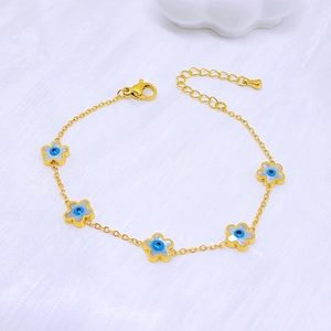 Golden titanium steel bracelet featuring blue shell flower charms on a white silk background