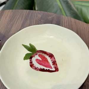 Pince à cheveux en acétate en forme de fraise avec strass sur un plateau blanc