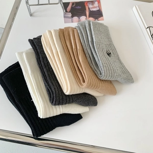 Detailed view of stacked striped cotton socks with embroidered bee in assorted neutral colors