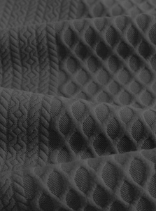 Detaillierte Nahaufnahme von dunkelgrauem Strickstoff mit 3D-Wabenstruktur