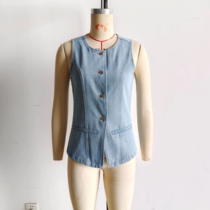 Détail du gilet en jean bleu clair délavé avec boutons métalliques et coutures amincissantes