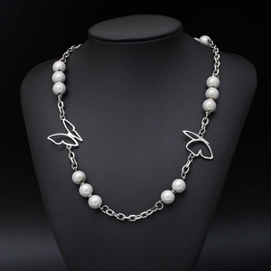 Titanium steel butterfly necklace with white pearls on a black neck bust display