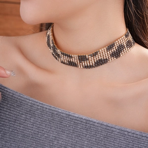Detail shot of a leopard print choker featuring gold-tone metal and shimmering rhinestones