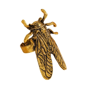 Dettaglio macro dell'anello a cicala con ali incise e finitura in oro antico vintage