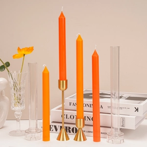 Long tapered orange candles with gold metal holders and plastic pillar candle molds set