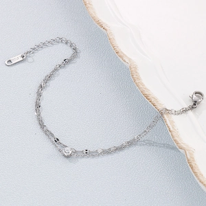 Dettaglio di un bracciale a doppio strato in acciaio argentato con zircone bianco tondo