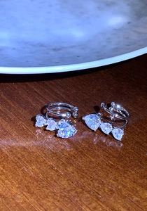 Detalle de primer plano de pendientes de presión con circonitas de corazón sobre madera