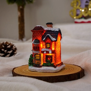 Macro shot of a glowing LED Christmas snow house with red brick and white snow