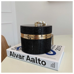 Detail of a cylindrical evening bag with black rhinestones and pearl handle